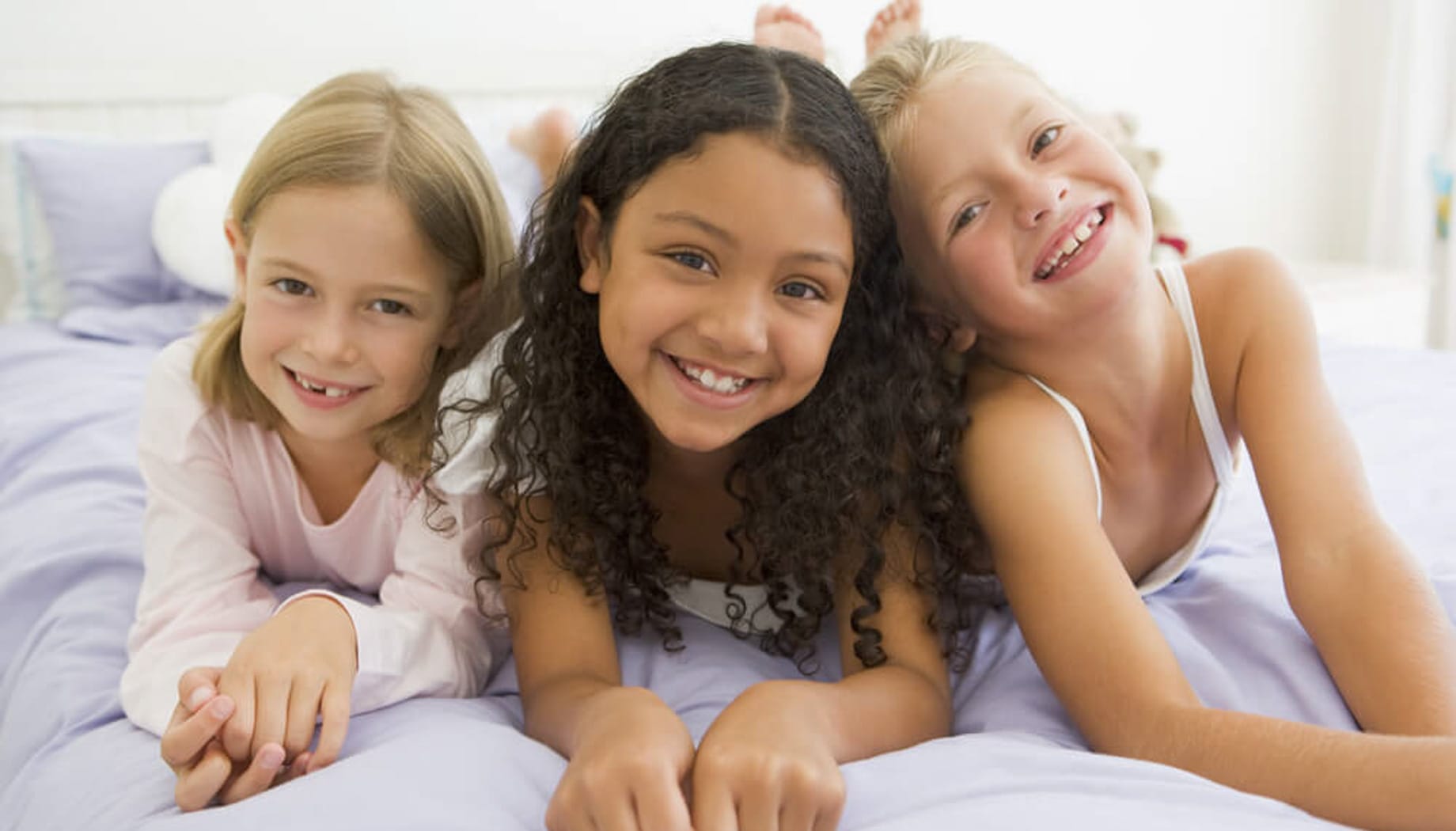 slumber-party Three girls smiling at the camera and getting ready for a slumber party.